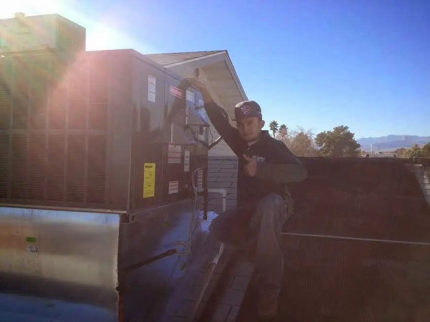 HVAC technician performing Heat Pump Repair on a rooftop unit in Arlington Heights